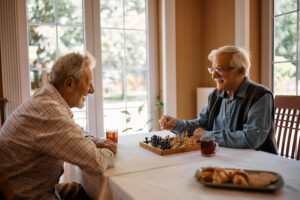 Happy senior men talk while playing chess.